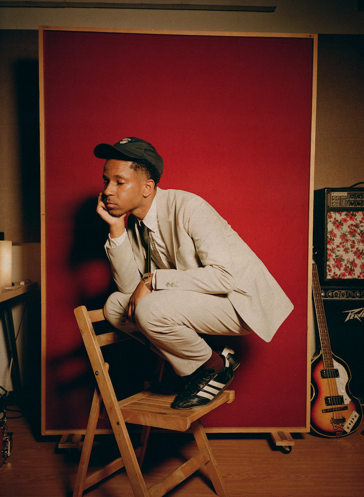 A photo of Isaia Huron against a red backdrop