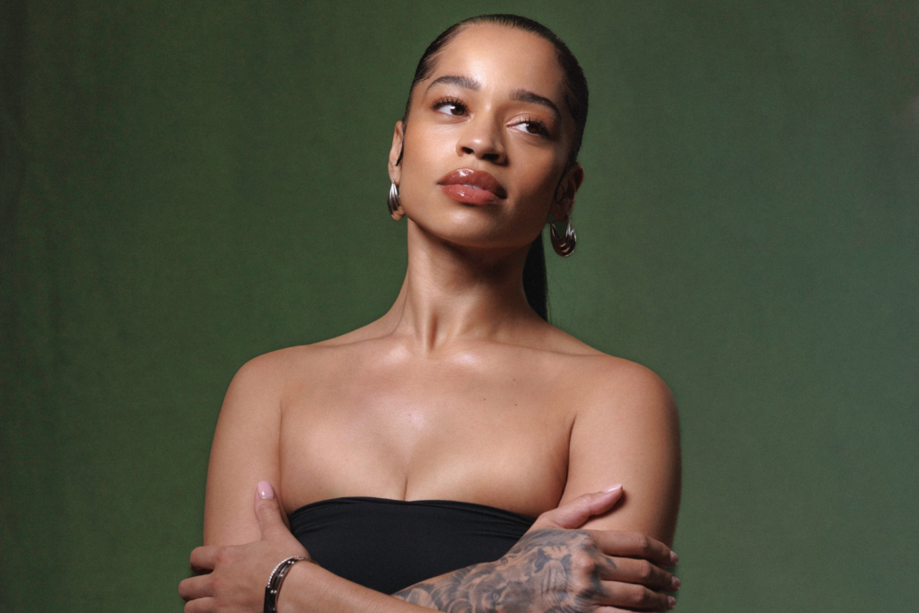 A photo of Ella Mai against a green backdrop